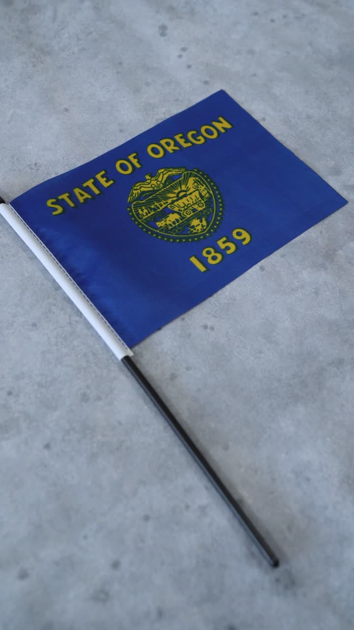 Inquadratura verticale della bandiera dello stato dell'Oregon. La camera orbita e si ingrandisce