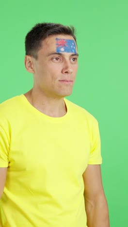 happy man with australian flag painted on face looking away
