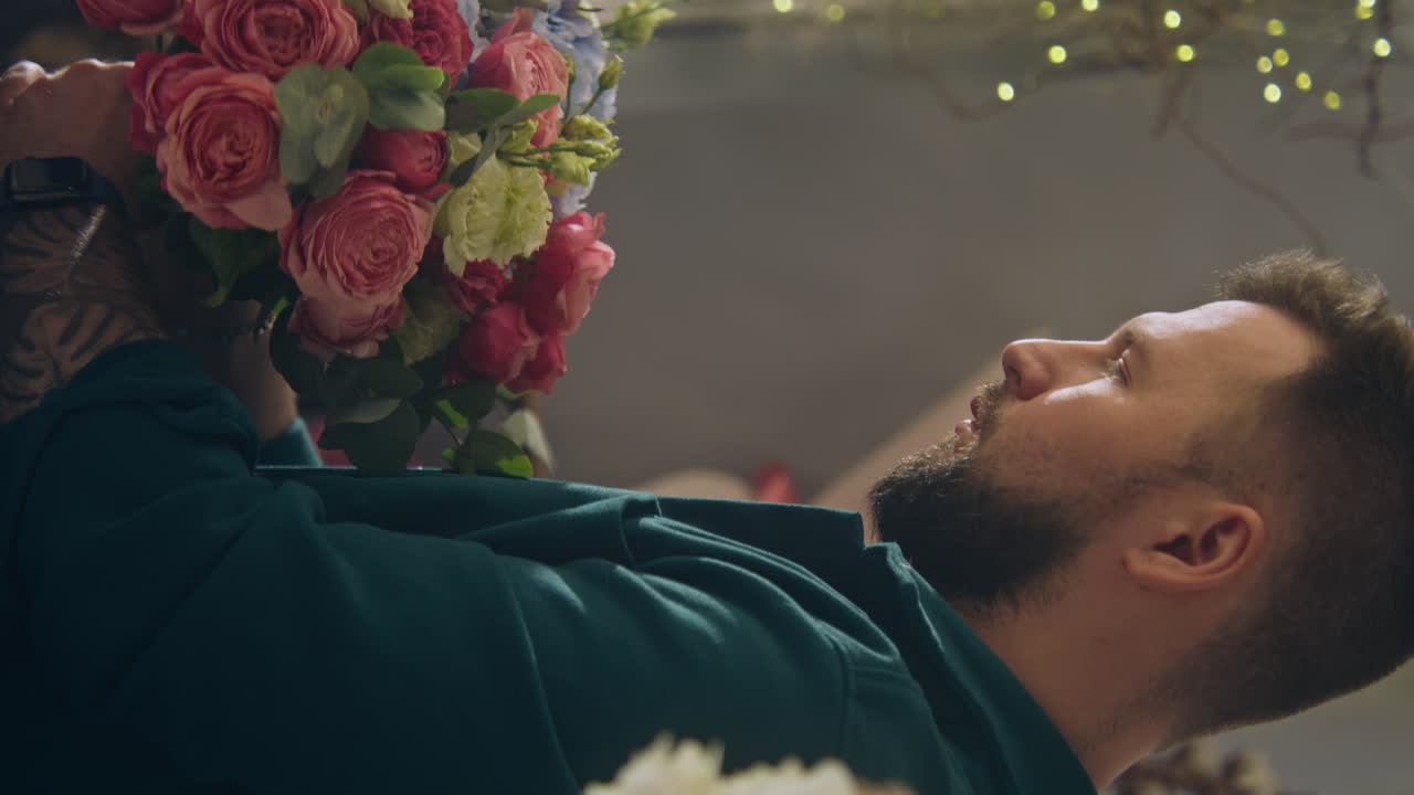 남성 플로리스트가 고객을 위해 꽃다발을 수집합니다.