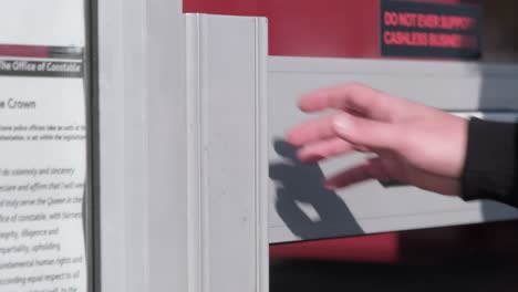 close up of male hand opening door into shop as he is walking in slow motion.
