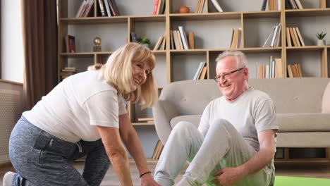 elderly retired couple do sports at home grandma helps grandpa do exercises elderly retired couple do sports at home grandma helps grandpa do exercises they spend time together doing sports