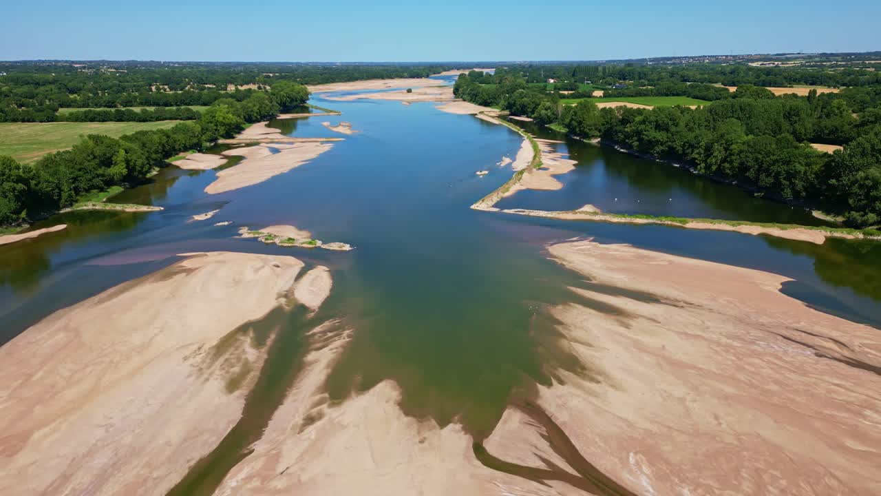 Drone backward shot from mid-Loire River showing both banks, low water level, and exposed sandbanks - Loireauxence in France