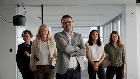 smiling businessman posing with his co-workers