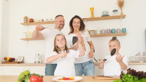 young family having fun dancing in the kitchen happily at home young family having fun dancing in the kitchen happily at home happy family in the kitchen having fun and cooking together