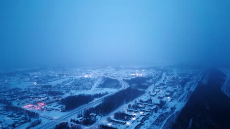 high aerial 4k sunrise blue hour morning cinematic 4k blizzard snowfall foggy glowing drone shot of arctic winter community isolated nunavut mining village hub of the north thompson manitoba canada