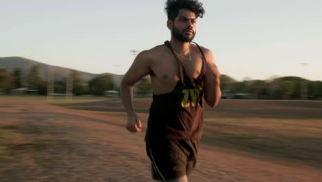 chico indio corriendo y entrenando para hacer ejercicio cardiovascular en un parque público durante la puesta de sol
