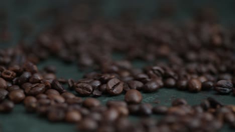 Dolly-right-of-coffee-beans-lying-on-the-dark-green-background