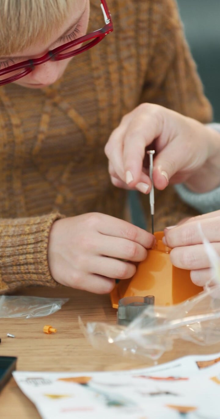 Bambino e adulto che assemblano insieme un modellino giocattolo