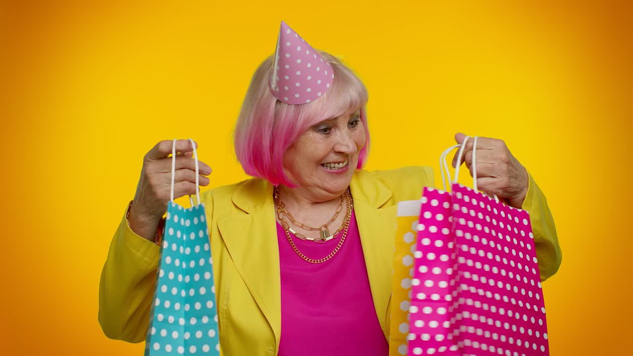 anciana abuela mostrando bolsas de compras, descuentos publicitarios, mirando asombrado con los precios bajos
