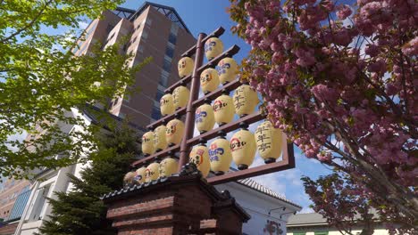 Looking-Up-At-Row-Of-Hanging-Lanterns-Outside-During-Daytime-In-Hakodate