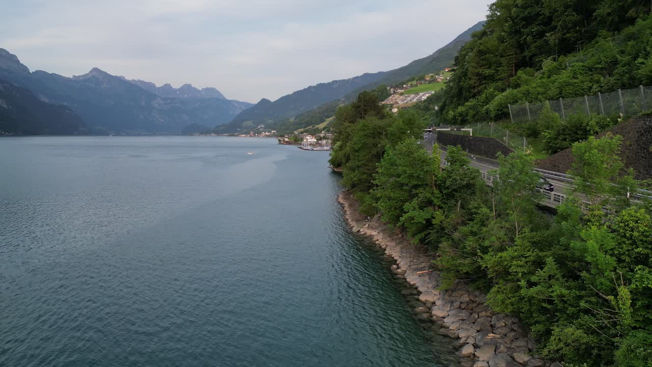 vehículos que pasan por una pintoresca carretera de montaña adornada por las aguas del lago walensee