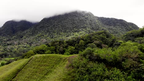 Mountain-clearing-and-rural-homes-in-Valle-de-Anton-Panama-inside-at-the-edge-of-extinct-volcano-crater,-Aerial-flyover-shot