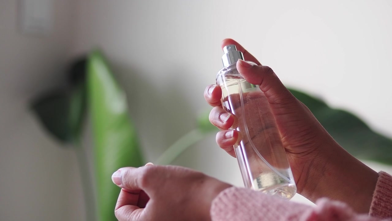 Person Spraying Perfume on Wrist