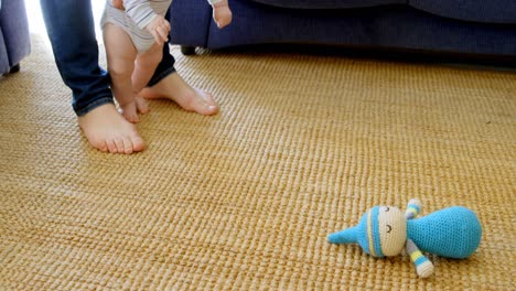 padre ayudando a su bebé a caminar en la sala de estar 4k