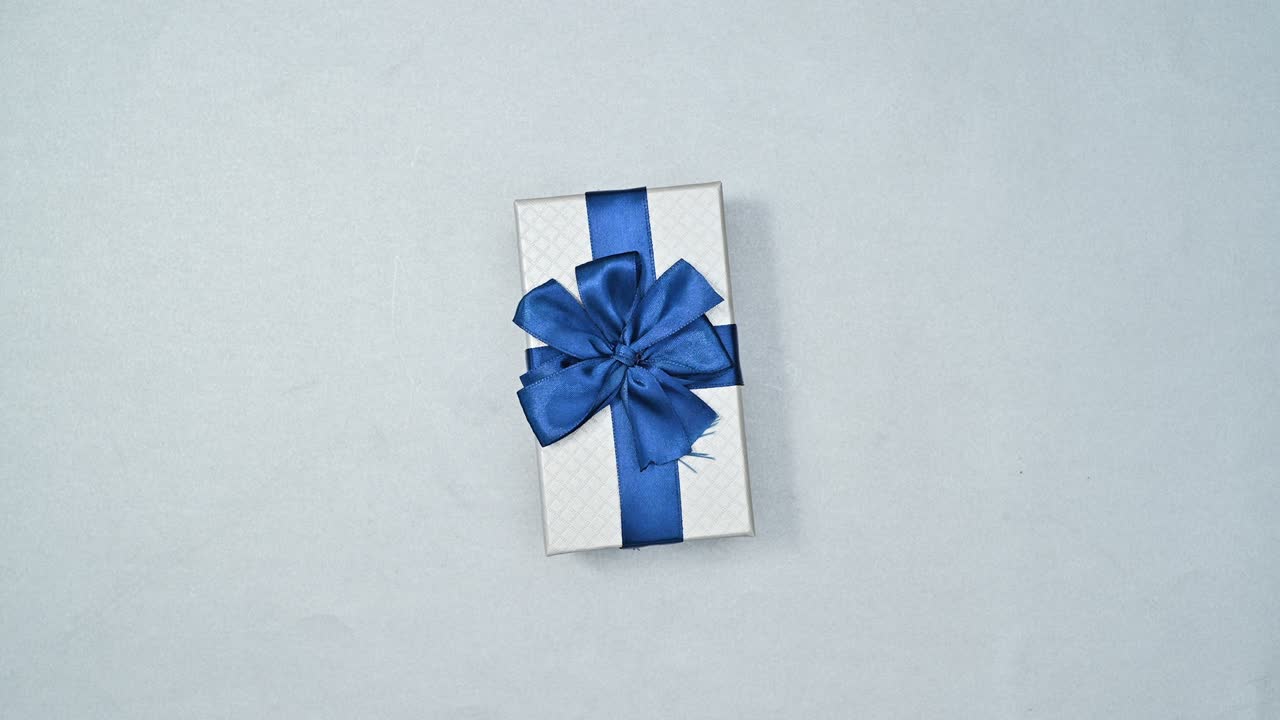 dos regalos de plata con cinta azul oscuro y rosa con cinta rosa girando y cambiando en el tema de plata. navidad stop motion