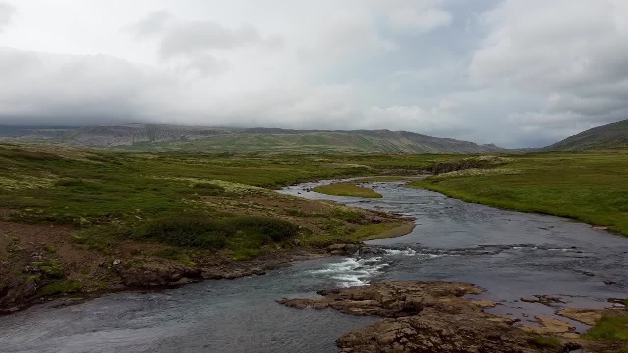 río curvo que fluye en una tierra plana en islandia en un día nublado, dolly in