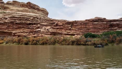 slow pan of guys in canoe on river in utah