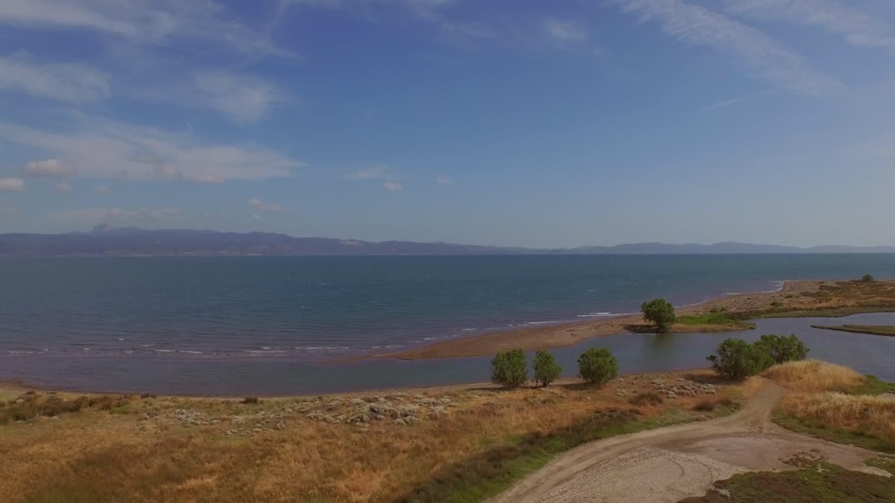antena: un delta de un río con un puente de carretera que lo atraviesa y algunos edificios agrícolas