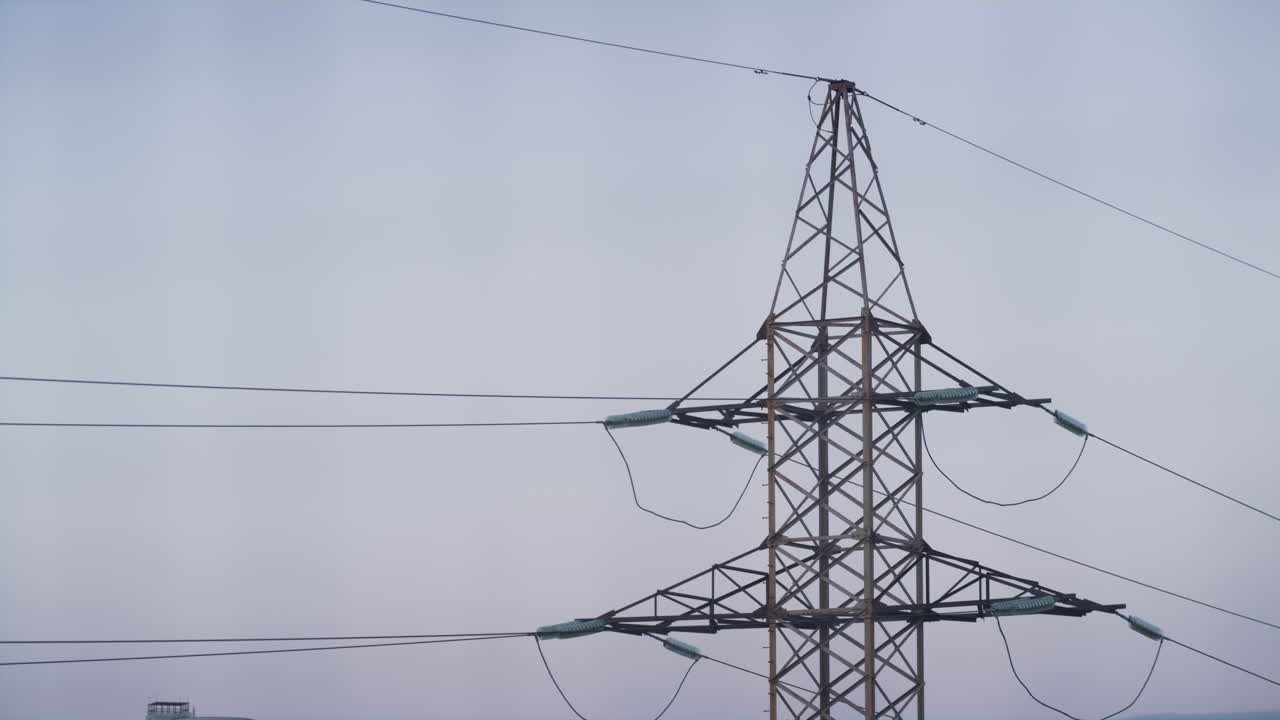 High voltage power pylon at clear sky drone shot. Parts of electrical equipment.