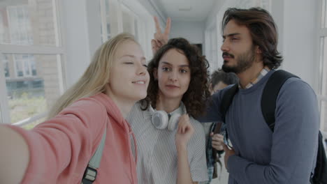 happy students taking a selfie in a university corridor