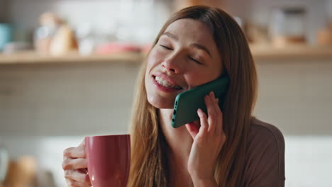 calling woman holding coffee cup enjoying home morning close up. smiling girl