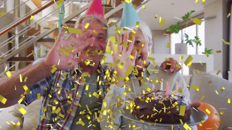 happy caucasian senior couple in party hats making birthday video call with cake and gold confetti