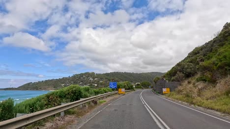 a 15-second video capturing a drive along the great ocean road, showcasing coastal views, winding roads, and lush greenery under a partly cloudy sky