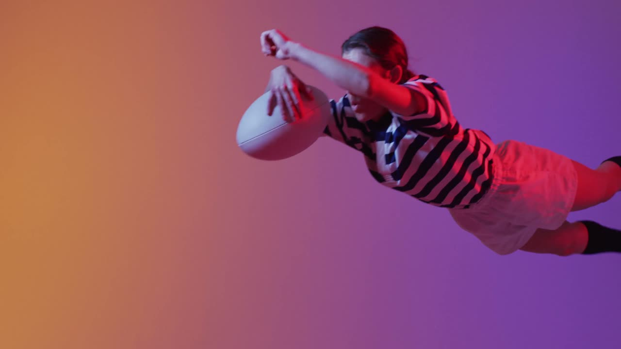 jugadora de rugby caucásica con una pelota de rugby sobre una iluminación rosa neón