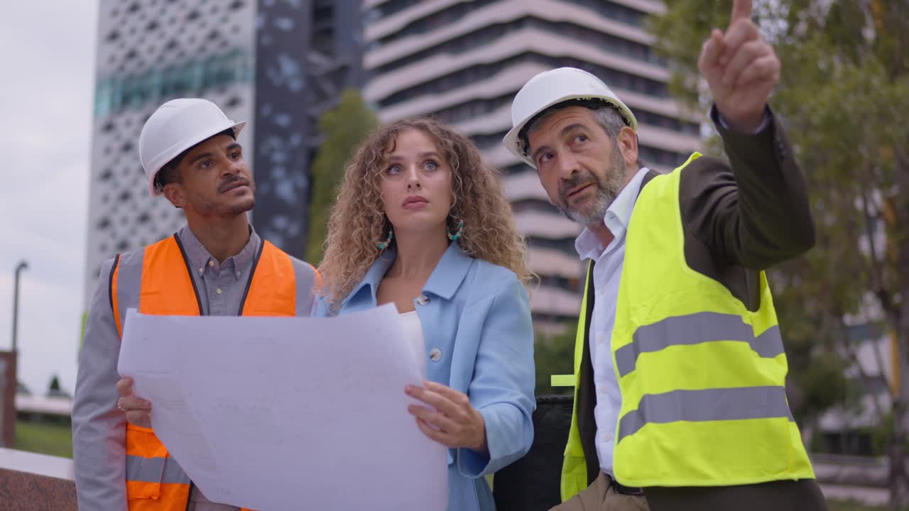 Construction team reviewing blueprints on site
