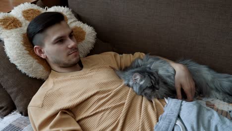 young man with his light gray fluffy cat