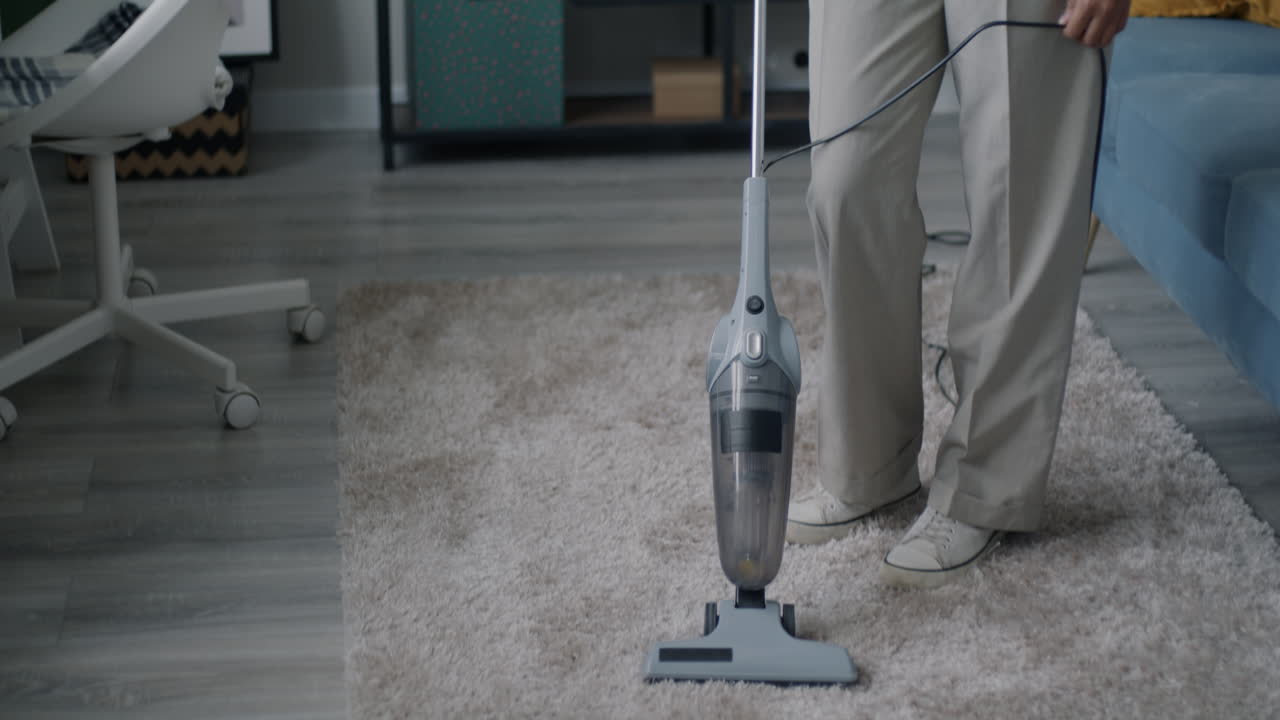Person Vacuuming a Living Room Carpet
