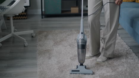 person vacuuming a living room carpet