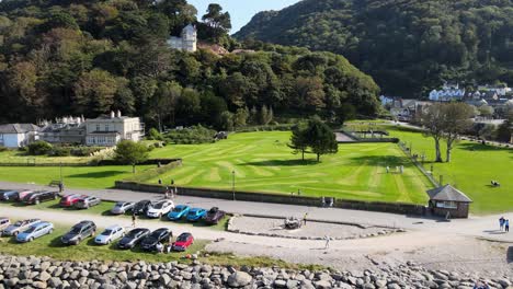 Lymouth-Park-Am-Meer-Drohnenschwenks-Entlang-Geparkter-Autos,-Die-Einen-Felsigen-Strand-Freigeben