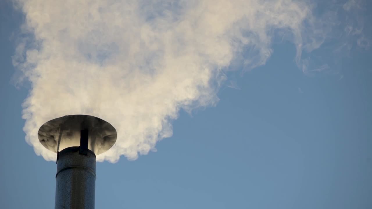 humo de una estufa de leña que sale de la chimenea