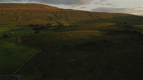 Aufsteigende,-Sich-Entwickelnde-Luftdrohnenaufnahme-Von-Whernside-Und-Hügeln-Zur-Goldenen-Stunde