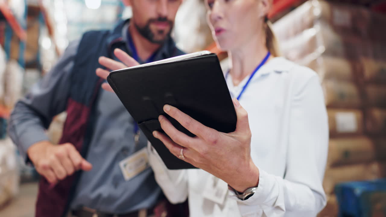 Warehouse employees using a tablet for inventory management