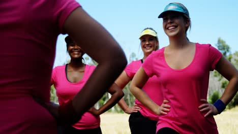 female trainer assisting women while exercising in the boot camp