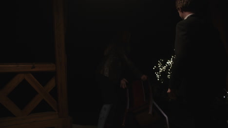 couple moving a chair outside at night