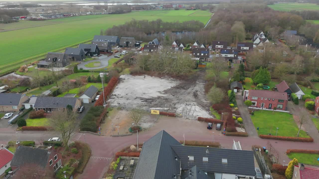 Stock aerial footage with rightward drone movement over an empty lot in Westerbroek, Netherlands. Vacant land where a school once stood, shown in calm winter daylight conditions