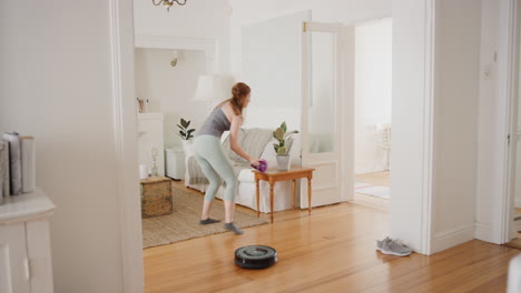 Mujer-Feliz-Bailando-En-Casa-Con-Robot-Aspirador-Haciendo-Tareas-Domésticas-Celebrando-Con-Un-Baile-Divertido-Divirtiéndose-Limpiando-La-Casa-4k