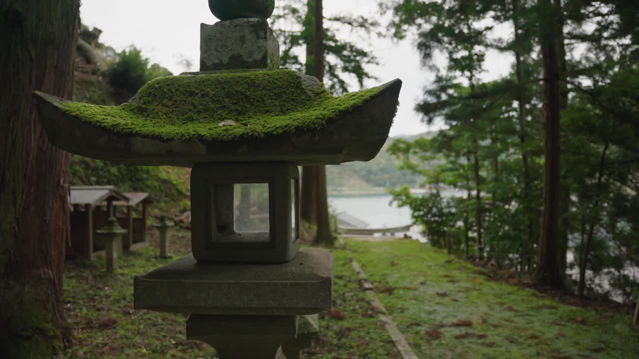 linterna cubierta de musgo con la costa de kioto en el fondo del japón rural
