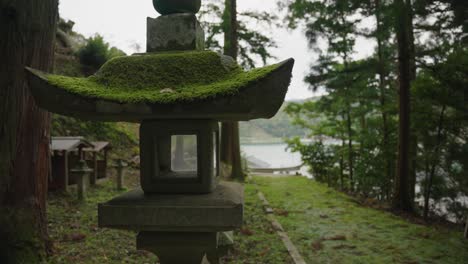 Mit-Moos-Bedeckte-Laterne-Mit-Kyoto-Meeresufer-Im-Hintergrund-Des-Ländlichen-Japans