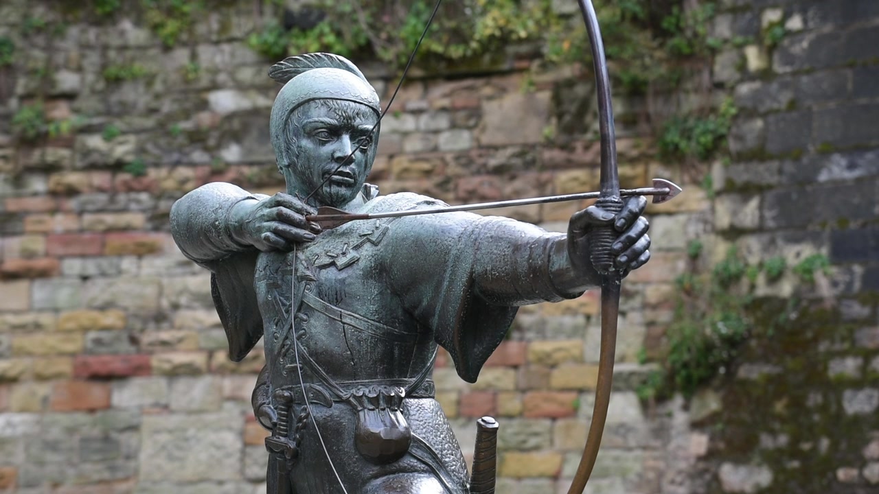 La statua di Robin Hood si erge fiera su Castle Road a Nottingham, Inghilterra, puntando la sua freccia verso lo storico corpo di guardia del Castello di Nottingham