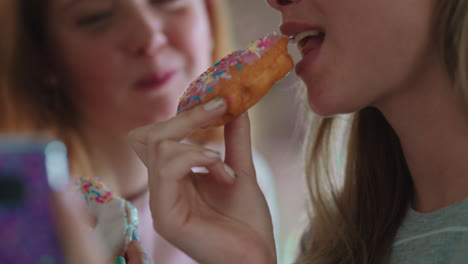 Cerrar-A-Una-Adolescente-Usando-Un-Teléfono-Inteligente-Navegando-Por-Las-Redes-Sociales-Enviando-Mensajes-De-Texto-A-Sus-Amigos-Comiendo-Donas