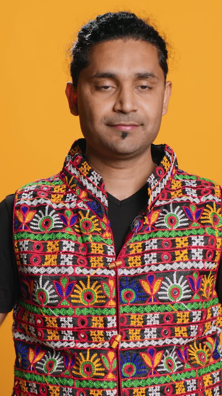 Man Making Heart Shape with Hands on Yellow Background