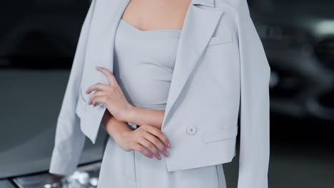 close-up of a woman's suit on a slender girl posing on a background of cars