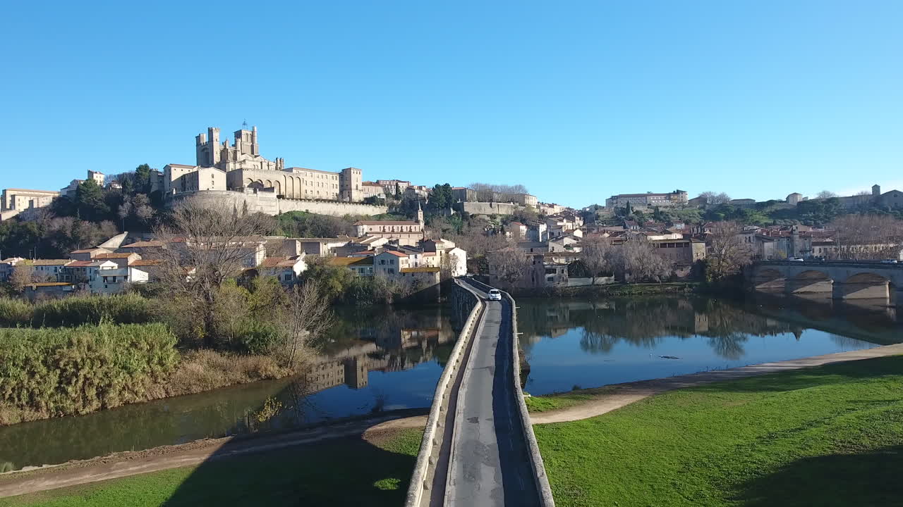 el coche cruza el pont vieux con la catedral de béziers en el fondo.