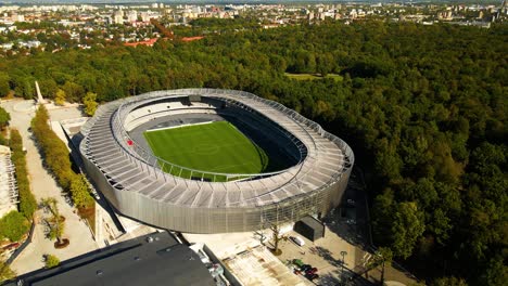 aerial-shot-of-a-newly-opened-Darius-and-Girenas-Stadium-and-oak-tree-park-on-a-sunny-summer-day-in-Kaunas,-Lithuania,-parallax