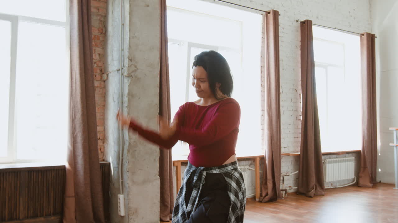 A young woman dances with energy and expression in a bright studio
