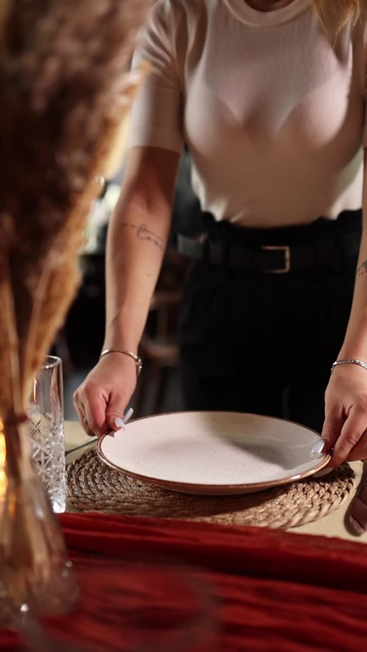Camarera colocando un plato en una mesa de comedor